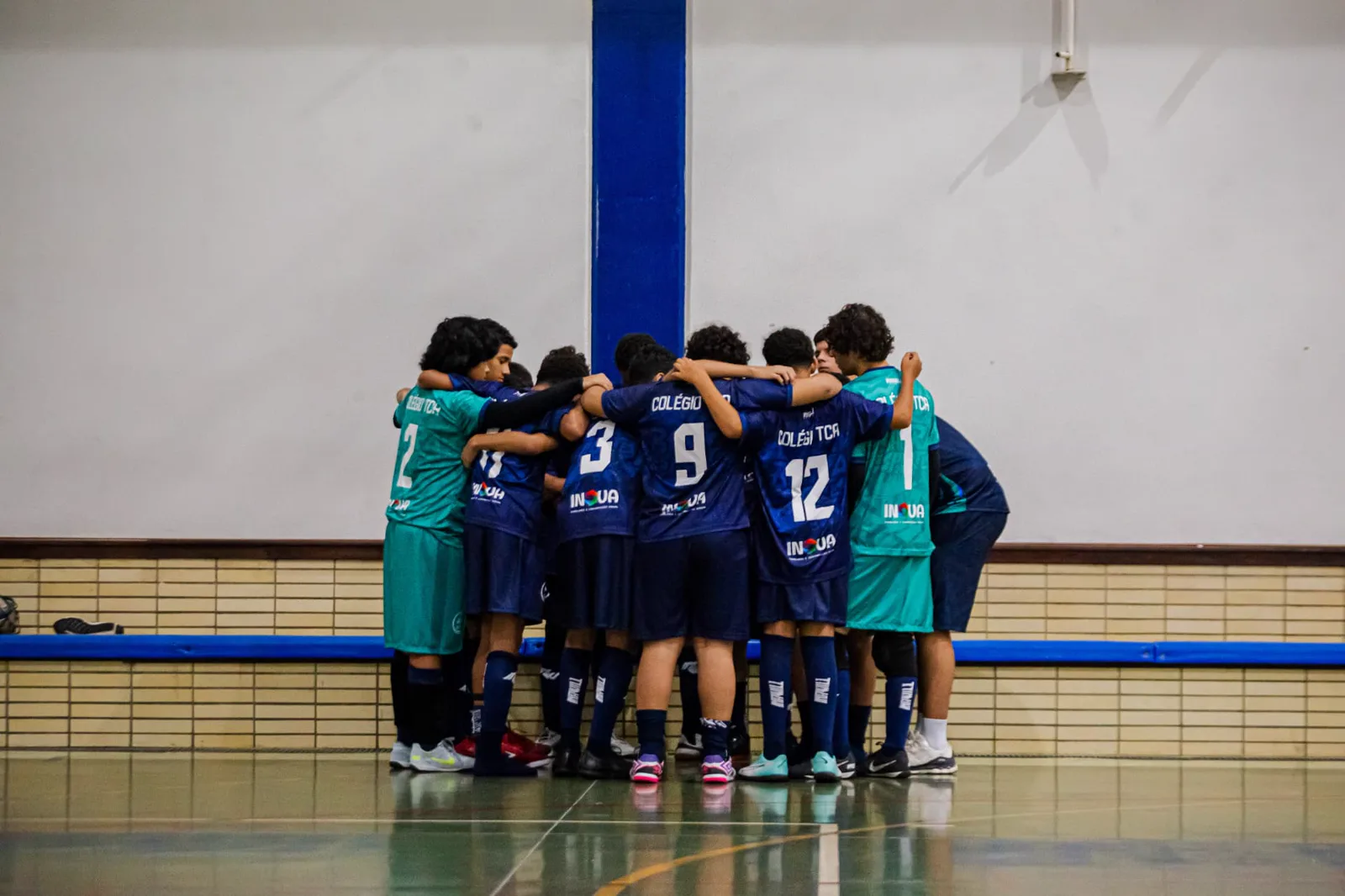 Equipe de futsal reunida em círculo antes do jogo